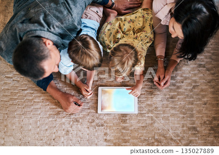 Tablet, screen and family streaming online content or social media on the internet and bonding in a home floor. Relax, mother and top view of father with children or kids in the living room using app Tablet, screen and family streaming online content or social media on the internet and bonding in a home floor. Relax, mother and top view of father with children or kids in the living room using app 135027889