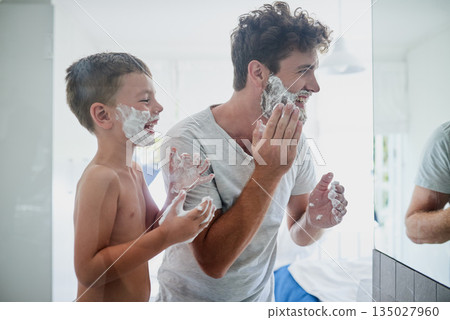 Kid, father and learning to shave, laughing and bonding together in bathroom. Funny, dad and teaching child with shaving cream on face beard, playing or cleaning, hygiene or enjoying hair removal. Kid, father and learning to shave, laughing and bonding together in bathroom. Funny, dad and teaching child with shaving cream on face beard, playing or cleaning, hygiene or enjoying hair removal. 135027960