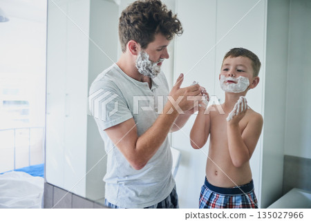 Father, kid and learning to shave in bathroom, education and bonding together. Care, dad and teaching child with shaving cream on face, playing or cleaning, hygiene or enjoying hair removal in home. Father, kid and learning to shave in bathroom, education and bonding together. Care, dad and teaching child with shaving cream on face, playing or cleaning, hygiene or enjoying hair removal in home. 135027966