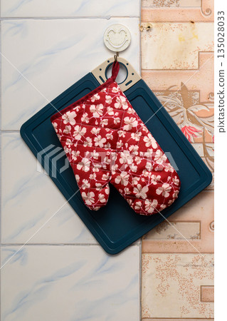 kitchen mitten lies on a cutting board on the wall kitchen mitten lies on a cutting board on the wall 135028033