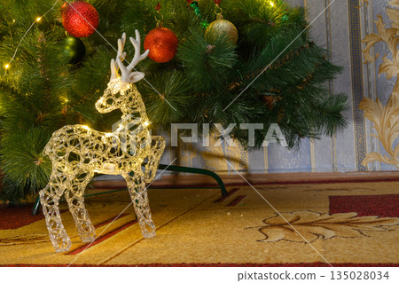 glowing reindeer figure under the Christmas tree glowing reindeer figure under the Christmas tree 135028034