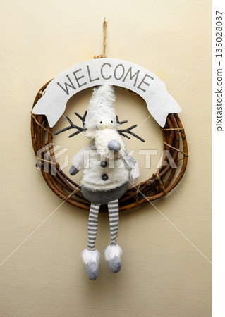 wicker wreath with a soft deer toy and welcome inscription on the wall wicker wreath with a soft deer toy and welcome inscription on the wall 135028037