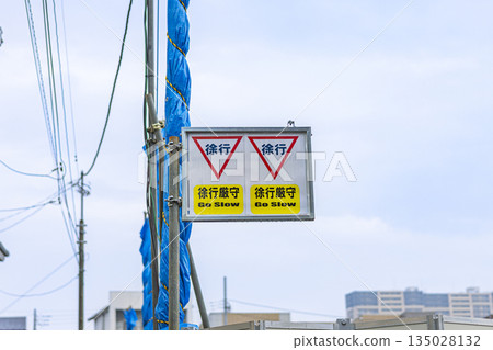 A sign at a construction site urging people to slow down A sign at a construction site urging people to slow down 135028132
