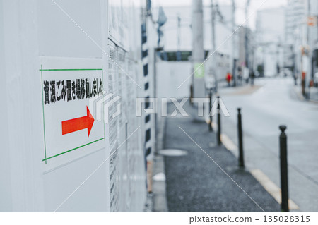 A notice posted on the temporary fence at the construction site announcing the change of the garbage dump site A notice posted on the temporary fence at the construction site announcing the change of the garbage dump site 135028315