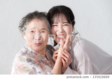 孫子和祖母面帶微笑，近距離看著鏡頭。 135028889