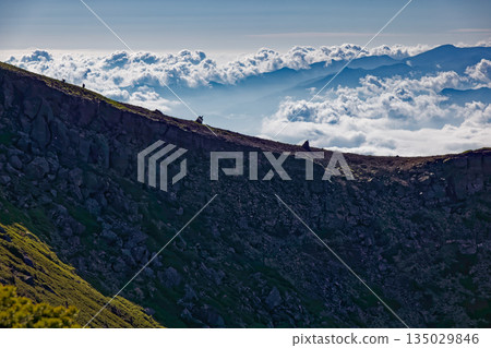 Climbers and sea of clouds going along the Yatsugatake mountain range and Iodake ridgeline Climbers and sea of clouds going along the Yatsugatake mountain range and Iodake ridgeline 135029846