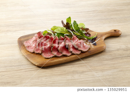 Roast beef served on a cutting board 135029951