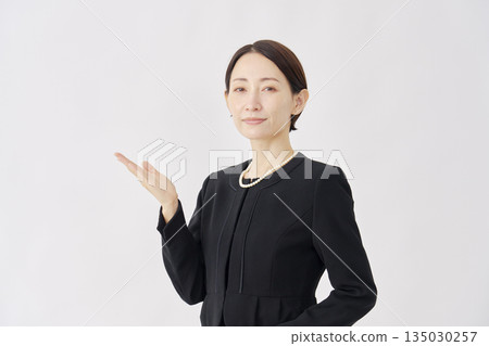 Woman in mourning clothes pointing to the left, white background Woman in mourning clothes pointing to the left, white background 135030257