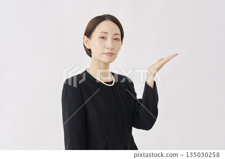 Woman in mourning clothes pointing to the right, white background Woman in mourning clothes pointing to the right, white background 135030258
