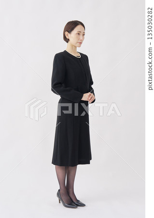 一位身著喪服的女子肖像，白色背景，全身像，面向右側。 135030282