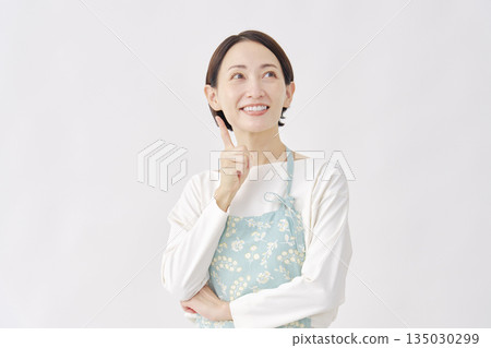 A woman wearing an apron has an idea. White background 135030299