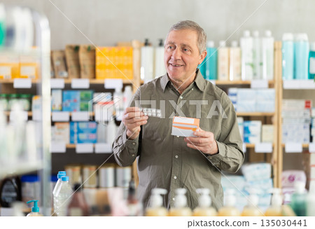 Senior man buys pills at pharmacy Senior man buys pills at pharmacy 135030441