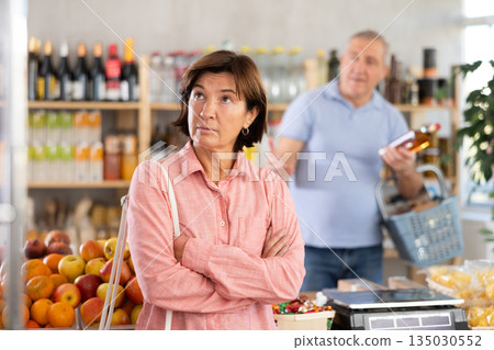 Elderly man quarrels with woman in grocery store 135030552