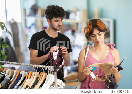 Couple spend time in shop and buy bra, girl choose and guy help to make purchase Couple spend time in shop and buy bra, girl choose and guy help to make purchase 135030766