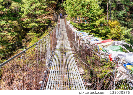 Suspension bridge over deep gorge in Himalayan mountains, Nepal. Suspension bridge over deep gorge in Himalayan mountains, Nepal. 135030876