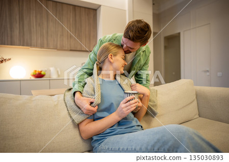 Cheerful smiling man and woman couple enjoying calm moments at home together, care in relationships. Cheerful smiling man and woman couple enjoying calm moments at home together, care in relationships. 135030893