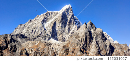 Helicopter flying between Himalayan peaks, view at Everest Base Camp trek in Nepal Helicopter flying between Himalayan peaks, view at Everest Base Camp trek in Nepal 135031027
