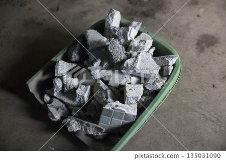 Concrete pieces in a large dustpan, rubble 135031090