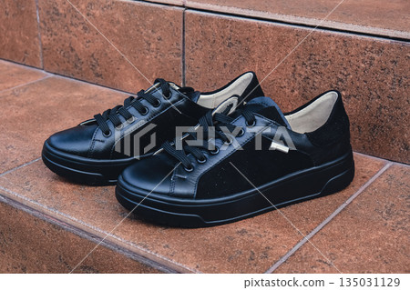 Elegant black leather womens shoes blank product for branding displayed. New casual female sneakers no-brand footwear e-commerce. No logo product 135031129
