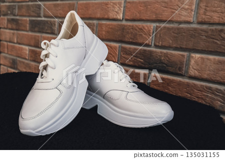Fresh beige leather sneakers without brand marks displayed. For design templates online shops and sustainability-themed marketing. Clean blank sneakers 135031155