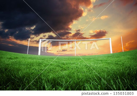 Football pitch under cloudy orange sky Football pitch under cloudy orange sky 135031803