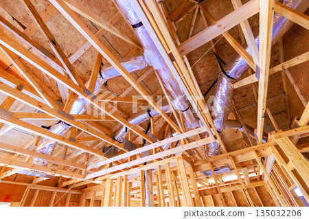 Workers are framing new building, s wooden beams, duct work in ceiling structure. 135032206
