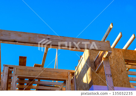 Workers build wooden structure with beams joist installation on roof 135032235