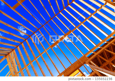 Wooden beams are being installed for new structure under roof frame trusses 135032236