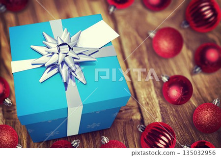 Vector graphic showcasing blue gift box with white ribbon, silver bow, red baubles on wood tabletop 135032956