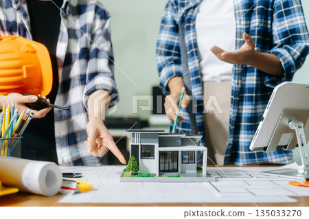 Creative architect projecting on the big drawings with architectural project at construction site at desk 135033270