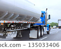 Large blue truck with tanker drives on highway near other vehicles 135033406