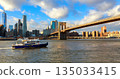 Brooklyn Bridge seen from boat in New York with city skyline 135033415
