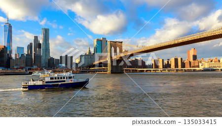 Brooklyn Bridge seen from boat in New York with city skyline 135033415