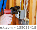 Electrician installs circuit breaker in new construction home 135033418