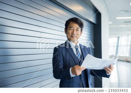 A businessman thinking in front of a store property 135033433