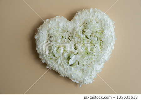Symbol of love beautiful flower petals in heart shape in beige background. Creative concept of St Valentines day, weeding romantic date or anniversary. Copy space Symbol of love beautiful flower petals in heart shape in beige background. Creative concept of St Valentines day, weeding romantic date or anniversary. Copy space 135033618