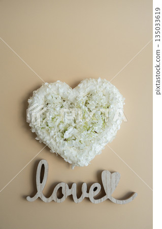 Wooden word LOVE White lilac flowers heart shaped in pastel backdrop. Symbol of love floral arrangement. Spring concept idea Valentine's Day, weeding proposal postcard copy space Wooden word LOVE White lilac flowers heart shaped in pastel backdrop. Symbol of love floral arrangement. Spring concept idea Valentine's Day, weeding proposal postcard copy space 135033619