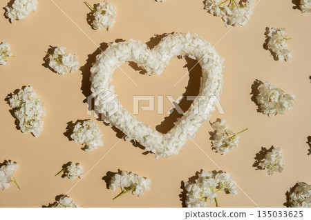 Symbol of love beautiful flower petals in heart shape in beige background. Creative concept of St Valentines day, weeding romantic date or anniversary. Copy space Symbol of love beautiful flower petals in heart shape in beige background. Creative concept of St Valentines day, weeding romantic date or anniversary. Copy space 135033625