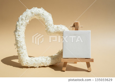 Heart made of white lilac flowers with white mock up paper template on pastel beige background. Still life romantic composition of Valentines day holiday copy space for your text invitation greeting Heart made of white lilac flowers with white mock up paper template on pastel beige background. Still life romantic composition of Valentines day holiday copy space for your text invitation greeting 135033629