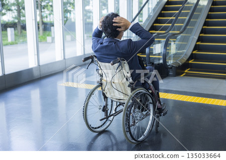 一名身穿西裝的男子坐在輪椅上 135033664