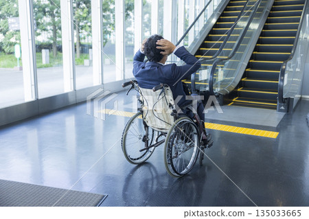 一名身穿西裝的男子坐在輪椅上 135033665