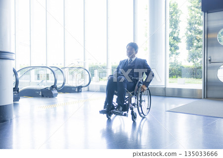 一名身穿西裝的男子坐在輪椅上 一名身穿西裝的男子坐在輪椅上 135033666