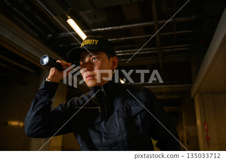Security guards inspect with flashlights 135033712