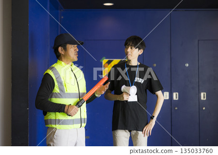 Staff guiding people at the event venue 135033760