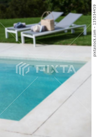Lounge chairs by swimming pool in backyard 135034459