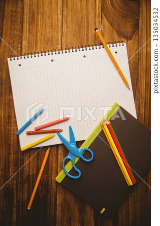 Flat design scene is showing spiral notebook is lying on wooden tabletop with crayons and pencils Flat design scene is showing spiral notebook is lying on wooden tabletop with crayons and pencils 135034532