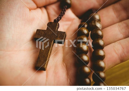 Hand holding rosary beads 135034767
