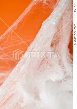 Spooky Halloween decoration with white cobweb on an orange background. Mockup, copy space, or template. Perfect for creating a festive atmosphere for Halloween parties or spooky projects Spooky Halloween decoration with white cobweb on an orange background. Mockup, copy space, or template. Perfect for creating a festive atmosphere for Halloween parties or spooky projects 135035145
