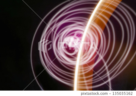 Abstract image of pink neon light painting in a circular and spiral pattern against a black background. A modern and futuristic design element Abstract image of pink neon light painting in a circular and spiral pattern against a black background. A modern and futuristic design element 135035162