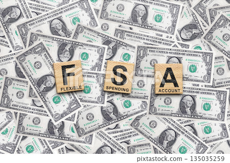 Wooden cubes spell out FSA with the words Flexible, Spending, and Account on them. The tiles are surrounded by a pile of US dollar bills. Concept of a Flexible Spending Account (FSA) Wooden cubes spell out FSA with the words Flexible, Spending, and Account on them. The tiles are surrounded by a pile of US dollar bills. Concept of a Flexible Spending Account (FSA) 135035259
